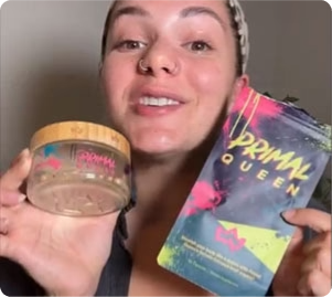 Person holding a jar and a packet labeled 'PRIMAL QUEEN' with a colorful design.