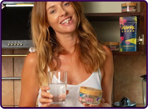 Person holding a glass of water and a jar in a kitchen setting.