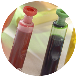 Two vials filled with red and green liquids.