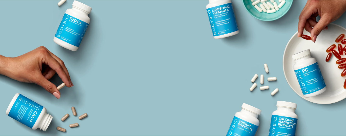 Various BodyBio supplement bottles and capsules on a blue background.