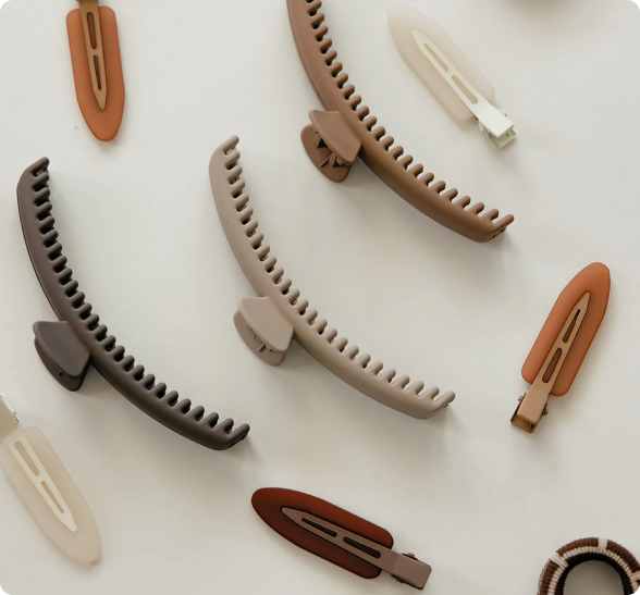 Assorted brown and beige hair clips arranged on a white background.