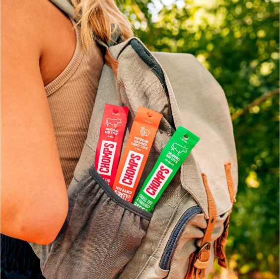 Backpack with Chomps meat sticks in the side pocket, outdoors.