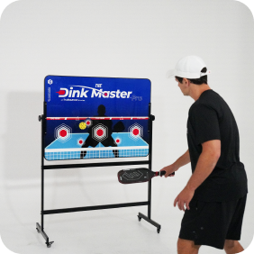 Person practicing pickleball with target board indoors.