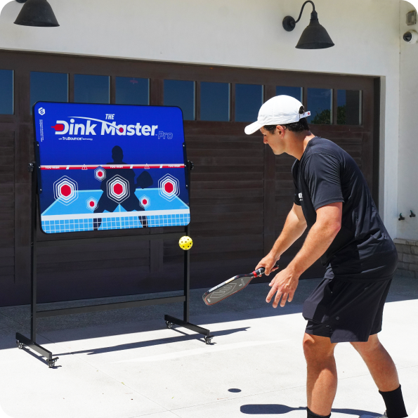 Person practicing pickleball with a 'Dink Master Pro' target board.