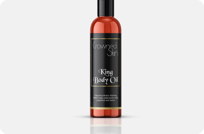 Bottle of Crowned Skin King Body Oil with black label on white background.