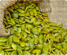 A burlap sack spilling out fresh green pumpkin seeds.