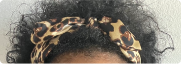 Curly hair with a leopard print headband.