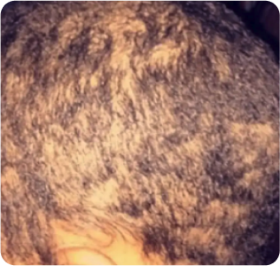 Close-up image of textured, short black hair with waves.