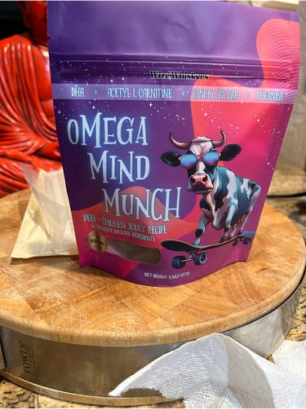 Colorful packaging of 'Omega Mind Munch' dog treats on a wooden surface.