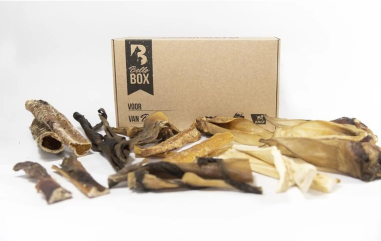 A box labeled 'BalloBox' with various dried dog treats spread out in front.