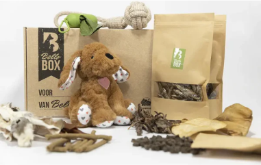 Pet subscription box with dog treats, toys, and plush stuffed animal.