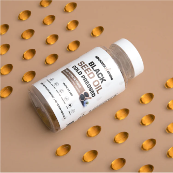 Bottle of black seed oil capsules on a beige background.