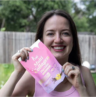 A person smiling and holding a packet of multi collagen peptides outdoors.