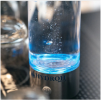 A clear bottle with blue liquid on a metal base labeled 'Hydrojii.'