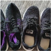 Two pairs of black running shoes on a gray carpet.