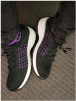 Black and purple sneakers on a gray carpet.
