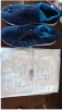 Blue athletic shoes next to a sealed package on a table.