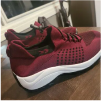 Pair of red athletic shoes on a wooden table.