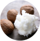 Shea nuts and shea butter on a wooden surface.