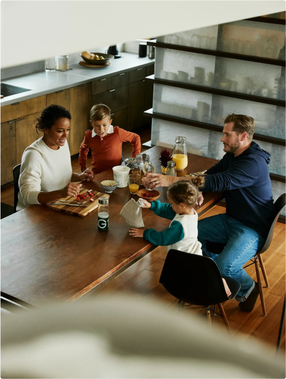 A family of four enjoys breakfast together at their kitchen table.