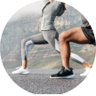 Two people doing lunges in athletic clothing outdoors.
