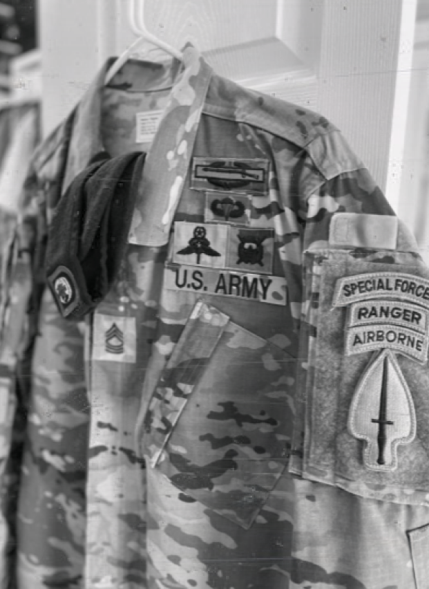 U.S. Army uniform with Special Forces and Ranger patches hanging on a door.