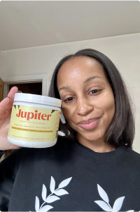 A person holding a container labeled 'Jupiter' and smiling.