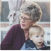 Older woman holding a young child outdoors.