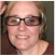 A person with glasses smiling at the camera.