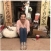 Person sitting on the floor in a living room with various items surrounding them.