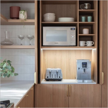 Kitchen cabinet with microwave, toaster, coffee machine, and neatly arranged shelves.