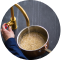 Hands rinsing rice in a pot under running water.