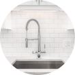 Modern kitchen faucet with white subway tile backsplash.