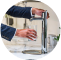 Hands filling a glass with water from a kitchen tap.