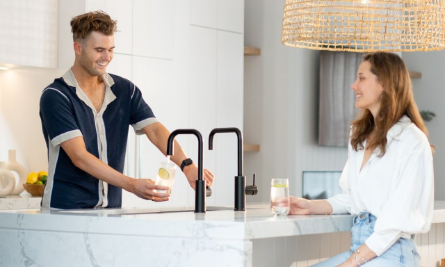 Two people enjoying drinks in a modern kitchen setting.