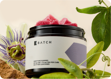 Jar of gummies surrounded by green leaves and a passion flower.