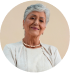 Elderly woman smiling warmly with a beige background.