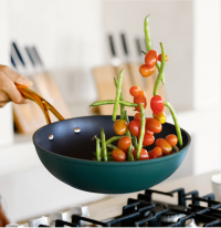Cooking vegetables in a frying pan over a stove.