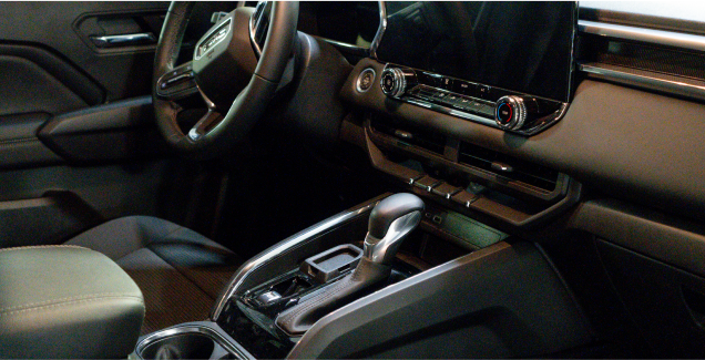 Modern car interior with a touchscreen, steering wheel, and gear shift.