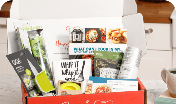 Subscription box with kitchen gadgets, spices, and recipe cards.