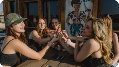 Group of women enjoying drinks together at an outdoor table.
