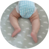 Baby lying on a cloud-patterned blanket, wearing a blue checkered diaper cover.
