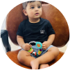 A seated child holding a colorful toy.