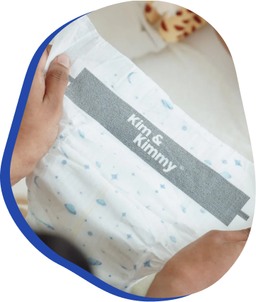 Person holding a diaper with 'Kim & Kimmy' label.