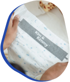 Person holding a gift wrapped in white and blue speckled paper.