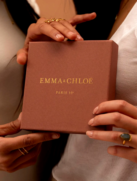Two people holding an Emma & Chloé box with jewelry.