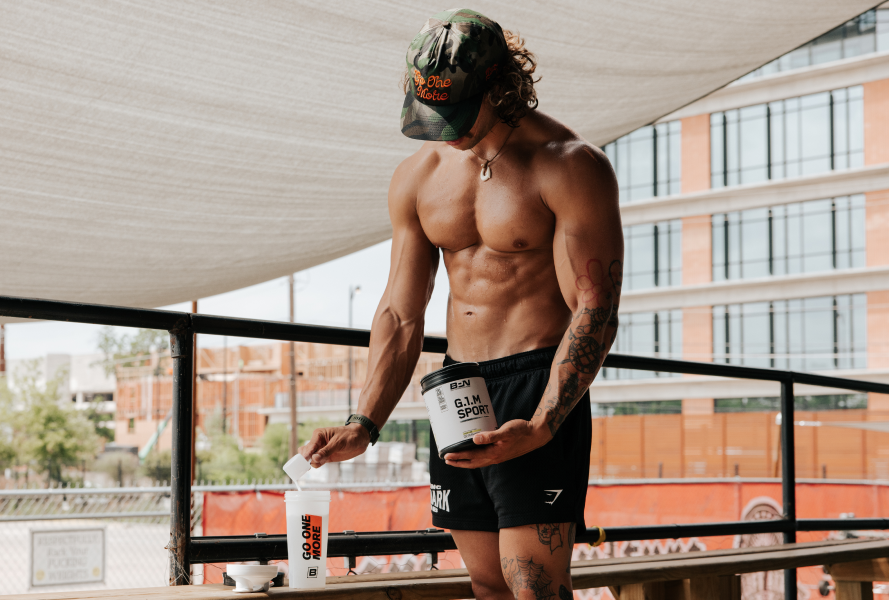 Man preparing protein shake on a balcony gym area.