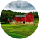 A red barn surrounded by lush green fields under a cloudy sky.