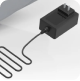 A black electronic device with a cord on a white surface.