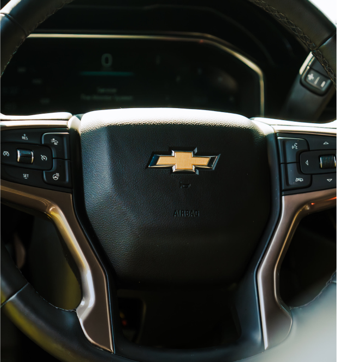 Close-up view of a Chevrolet steering wheel with control buttons visible.